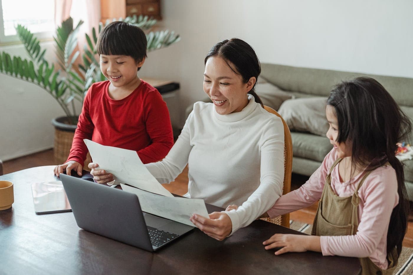 Mother talking with her school-age children at the dining table