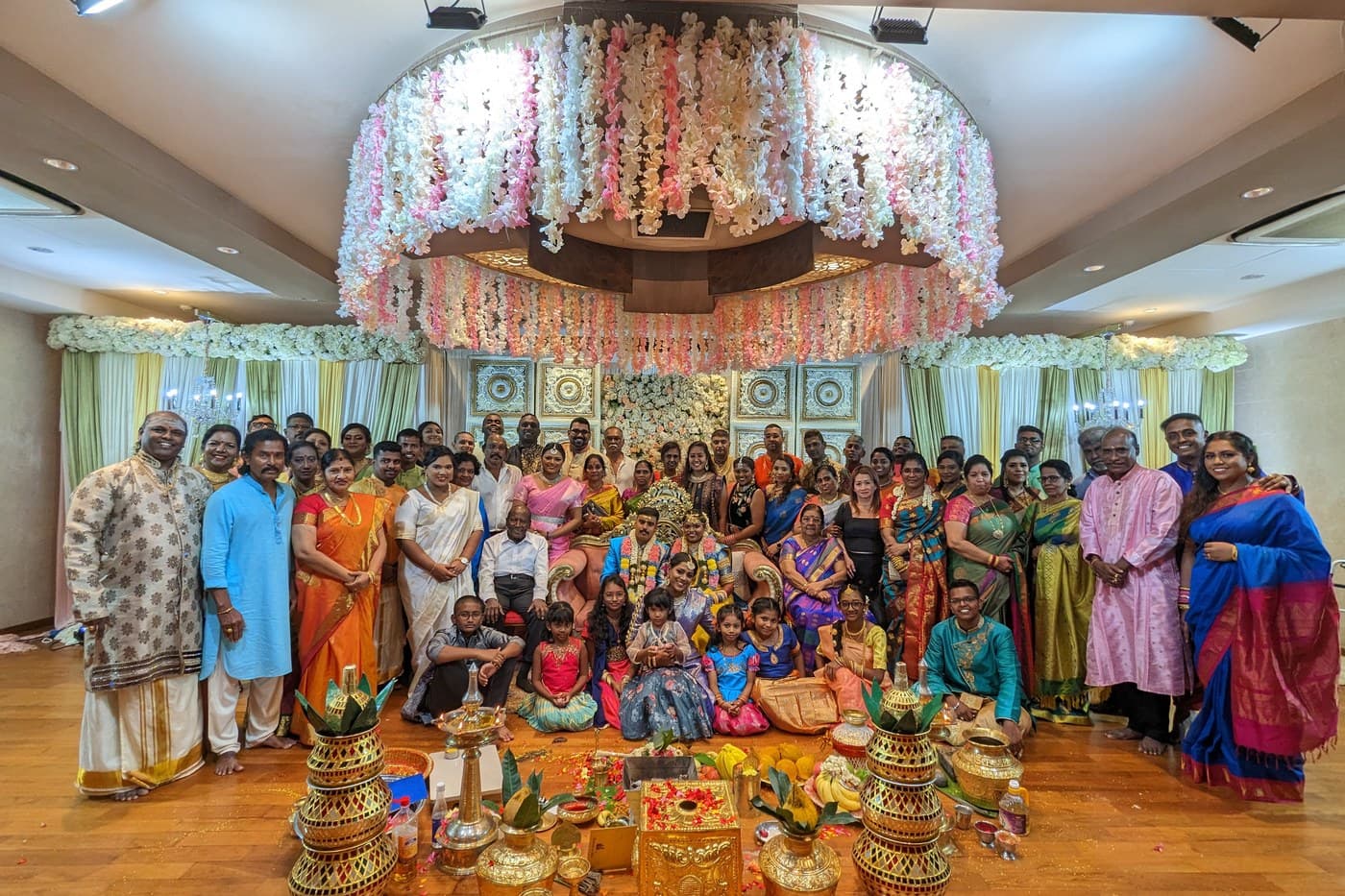 Bride, groom, and extended family gathered for a traditional Indian wedding portrait