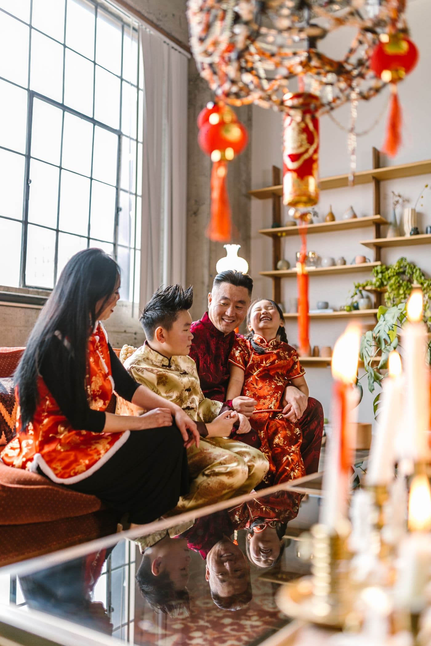 East Asian father smiling with his laughing children during a warm family moment at home