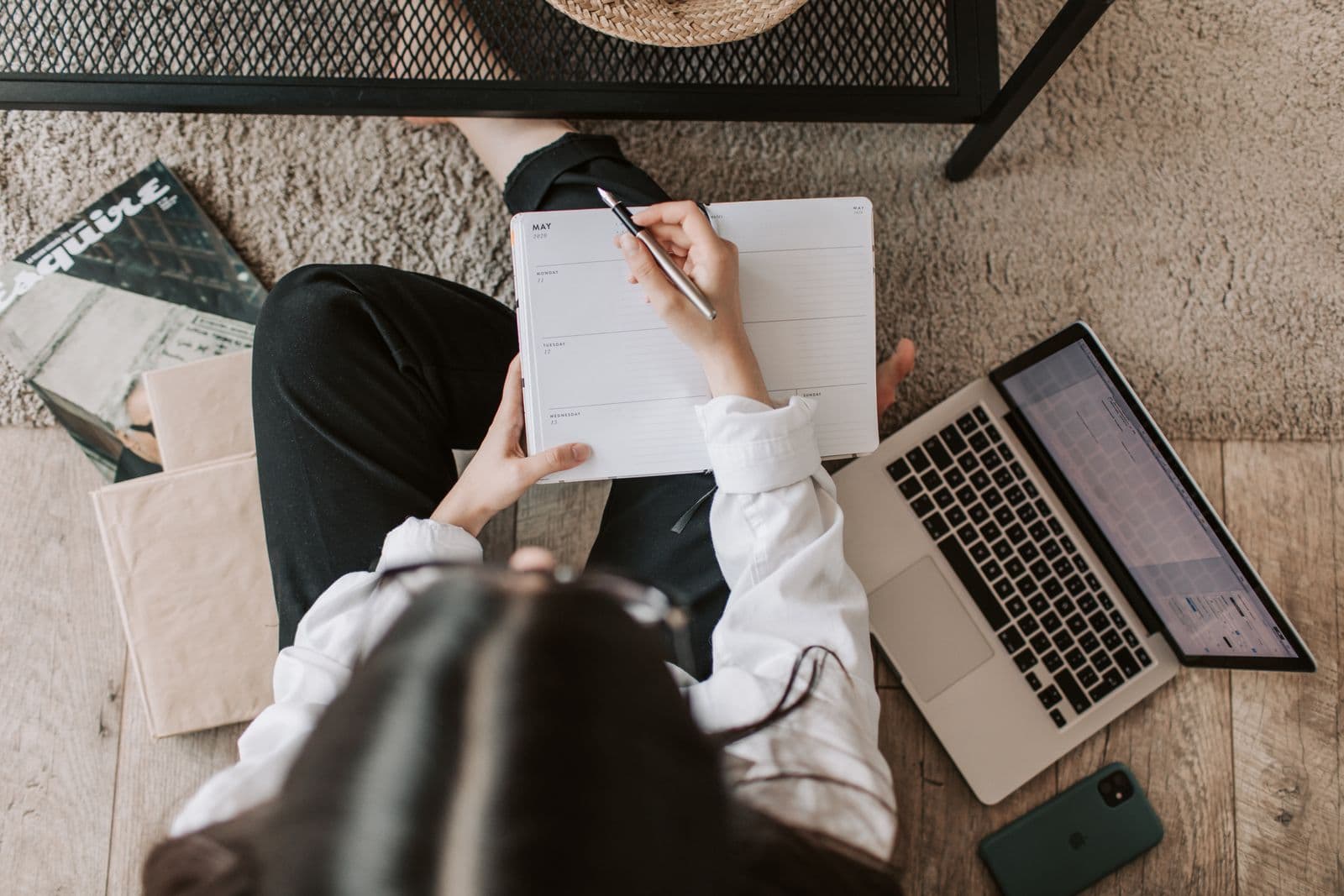 Person reviewing a planner and calendar while sorting home paperwork