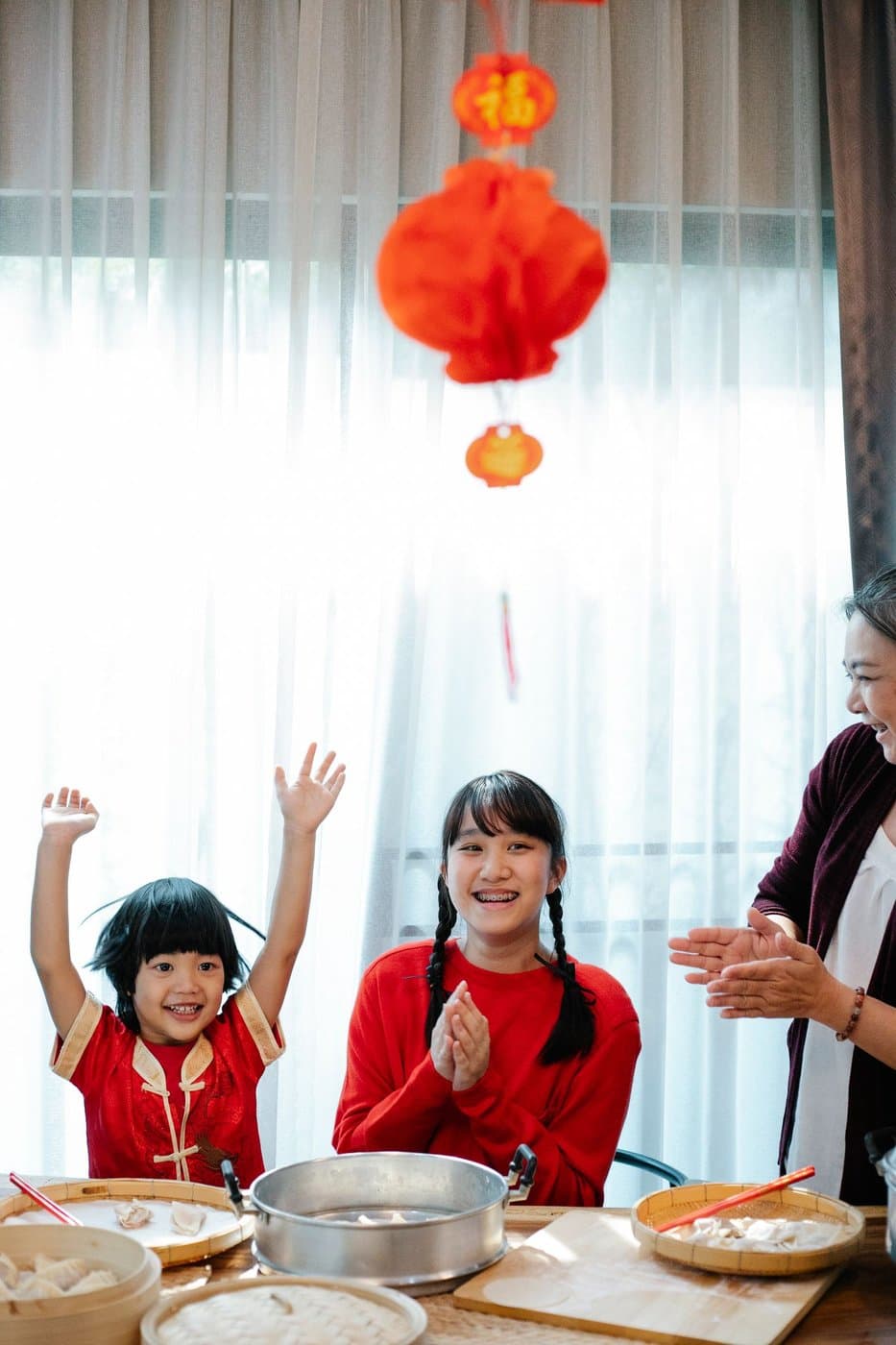 Family preparing dumplings together for a home celebration