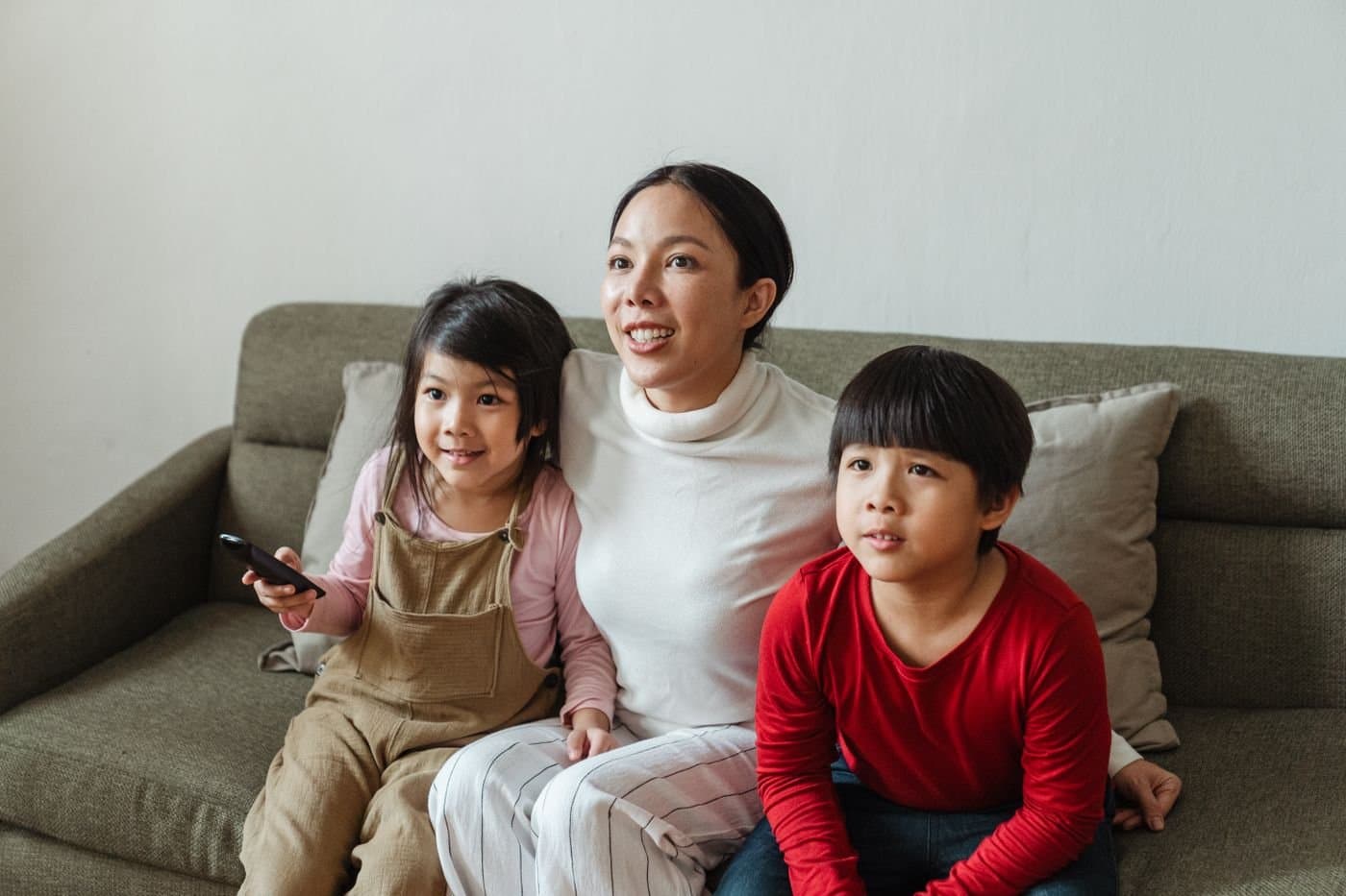 Mother and children sharing a quiet evening together on the living room sofa