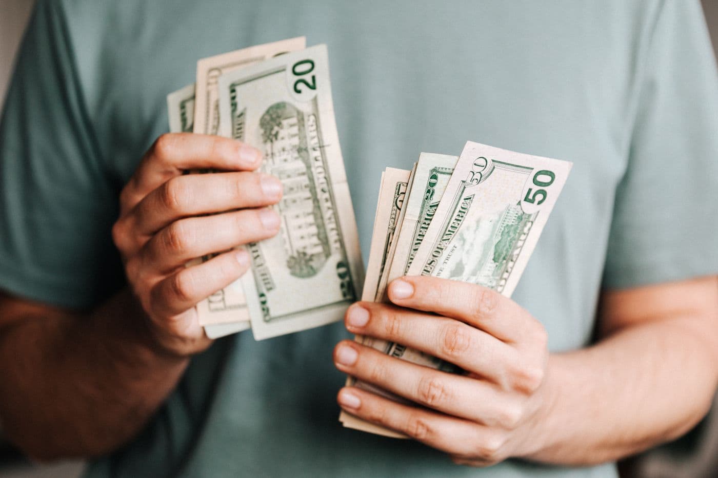 Hands counting US cash while reviewing household money decisions