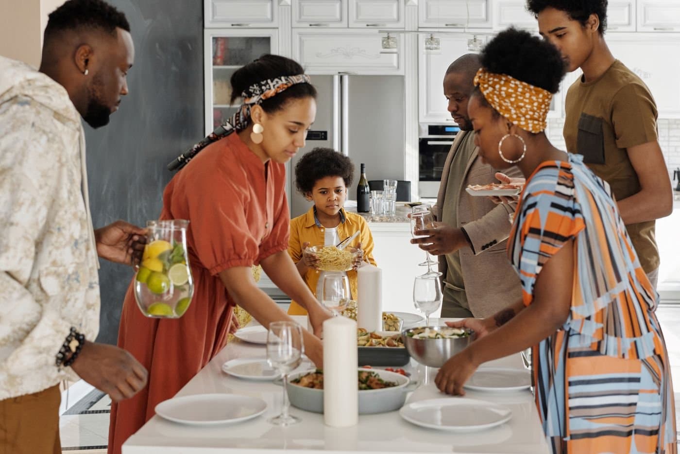 Multigenerational family setting the table for dinner at home