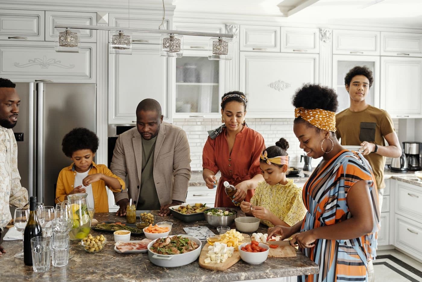 Large family preparing food together around a kitchen island