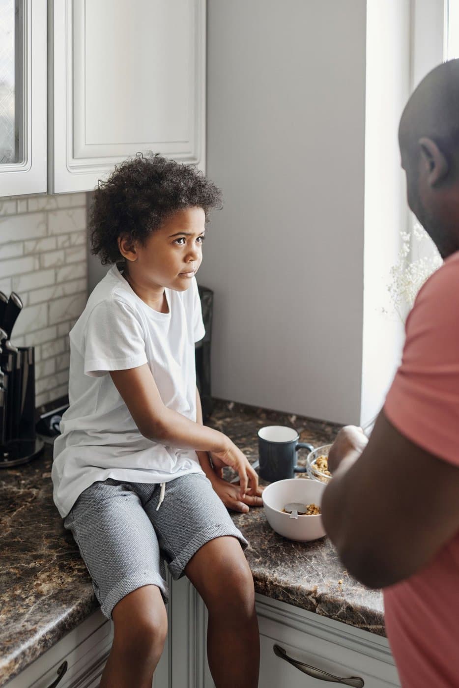 Father and son sharing a quiet moment at the kitchen counter