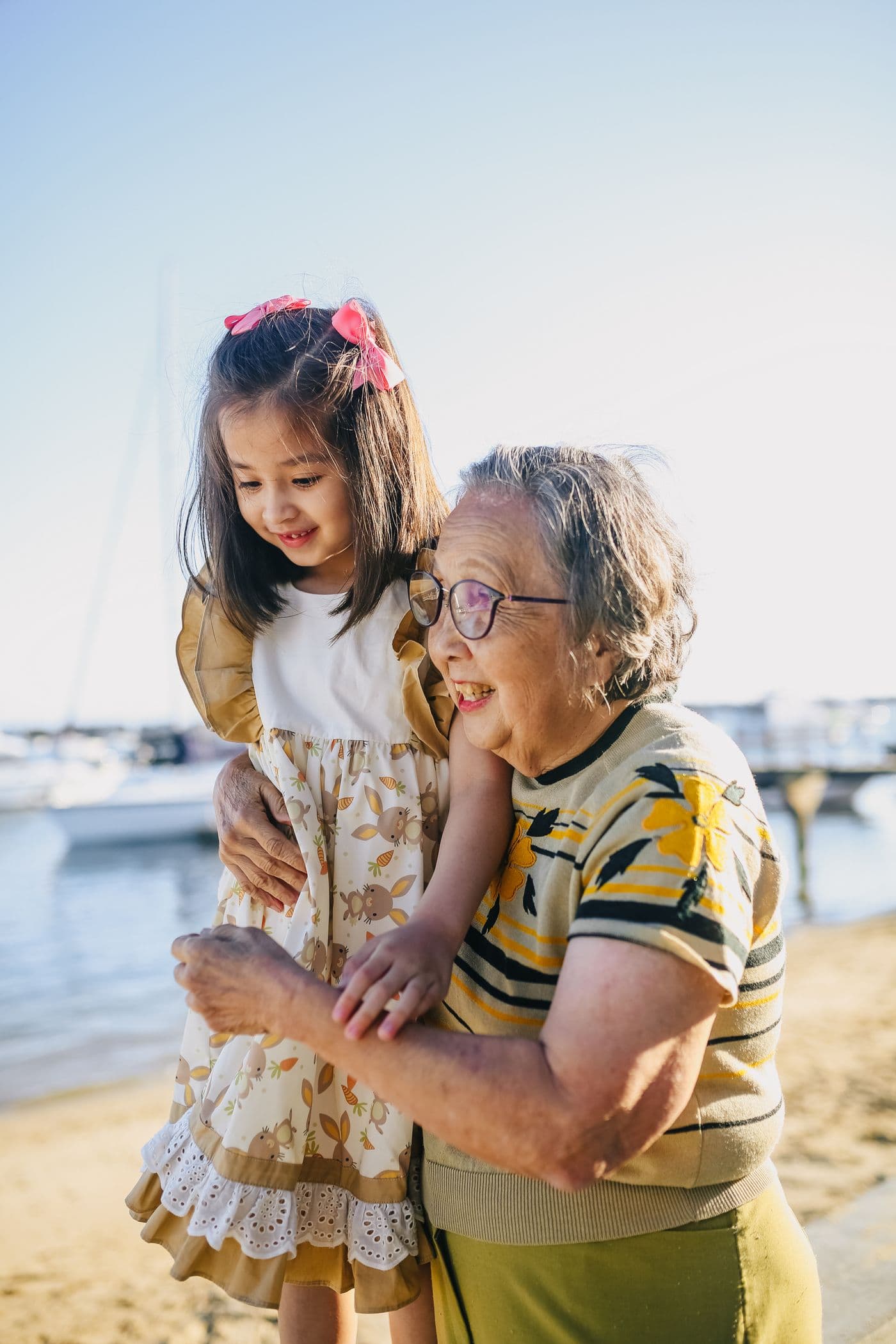 East Asian grandmother and granddaughter sharing a warm outdoor moment together