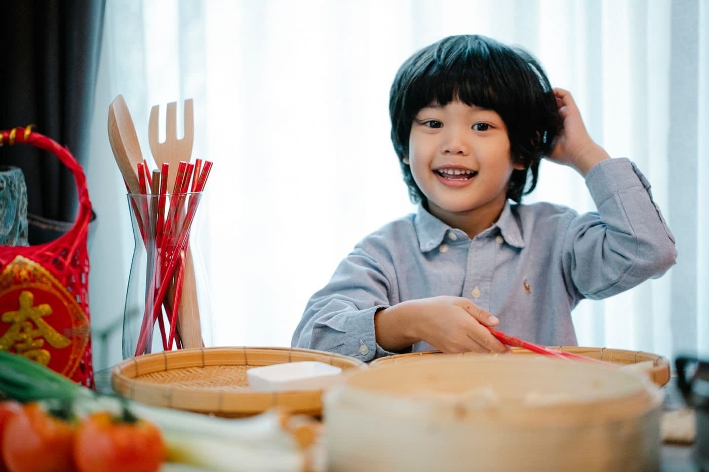 Child learning to use chopsticks during a festive family meal preparation