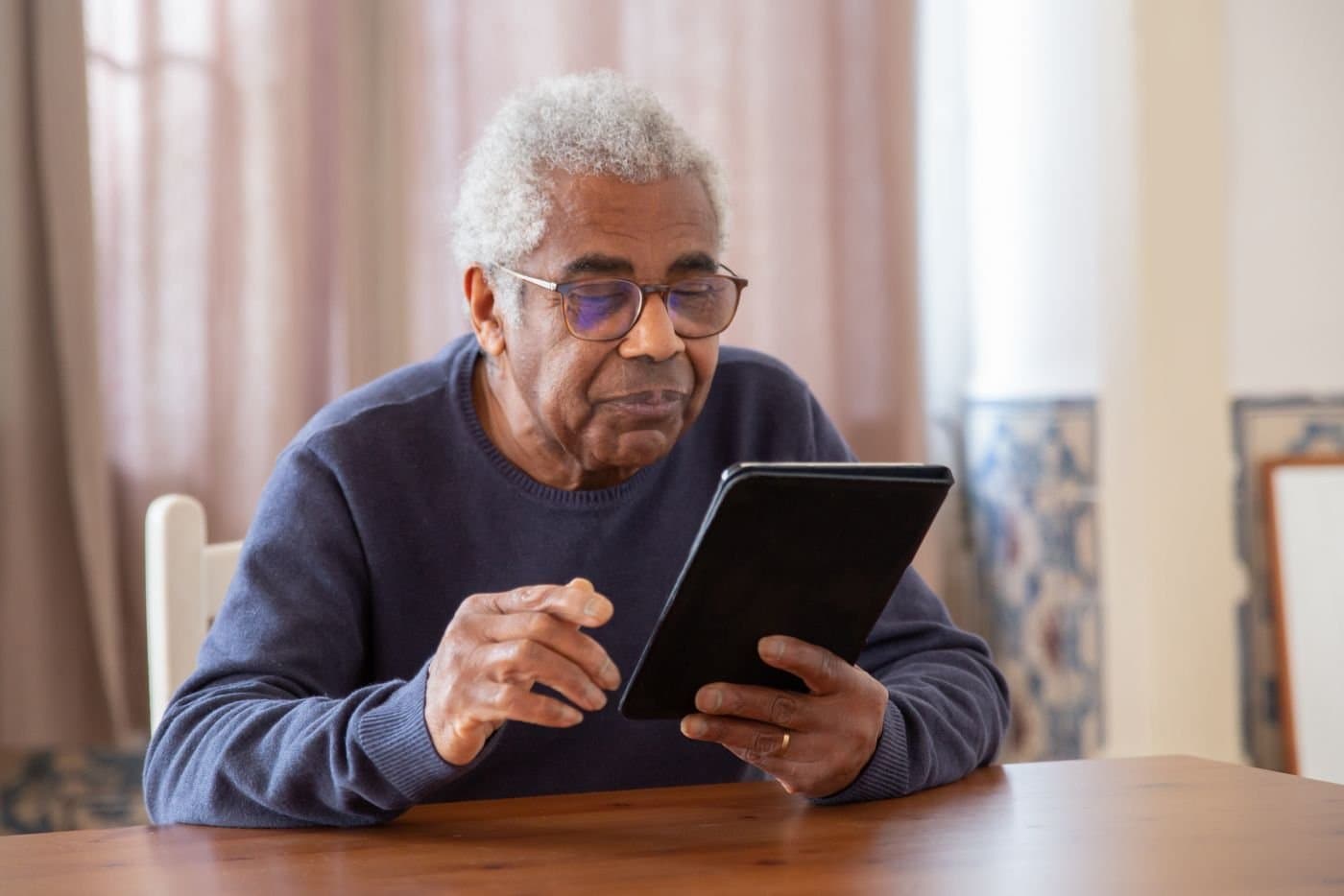 Grandparent using a tablet to stay connected with family at home