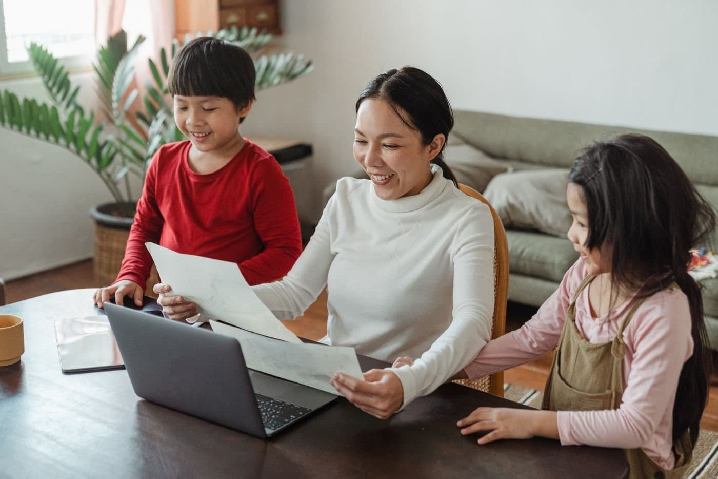 Mother talking with her school-age children at the dining table