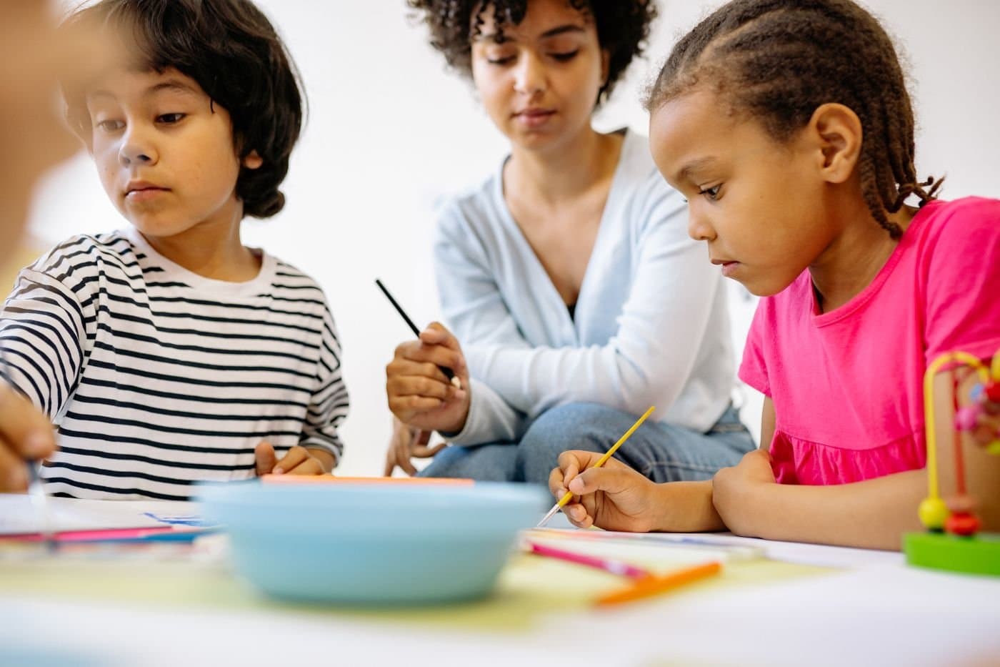 Caregiver painting with toddlers during a morning art activity