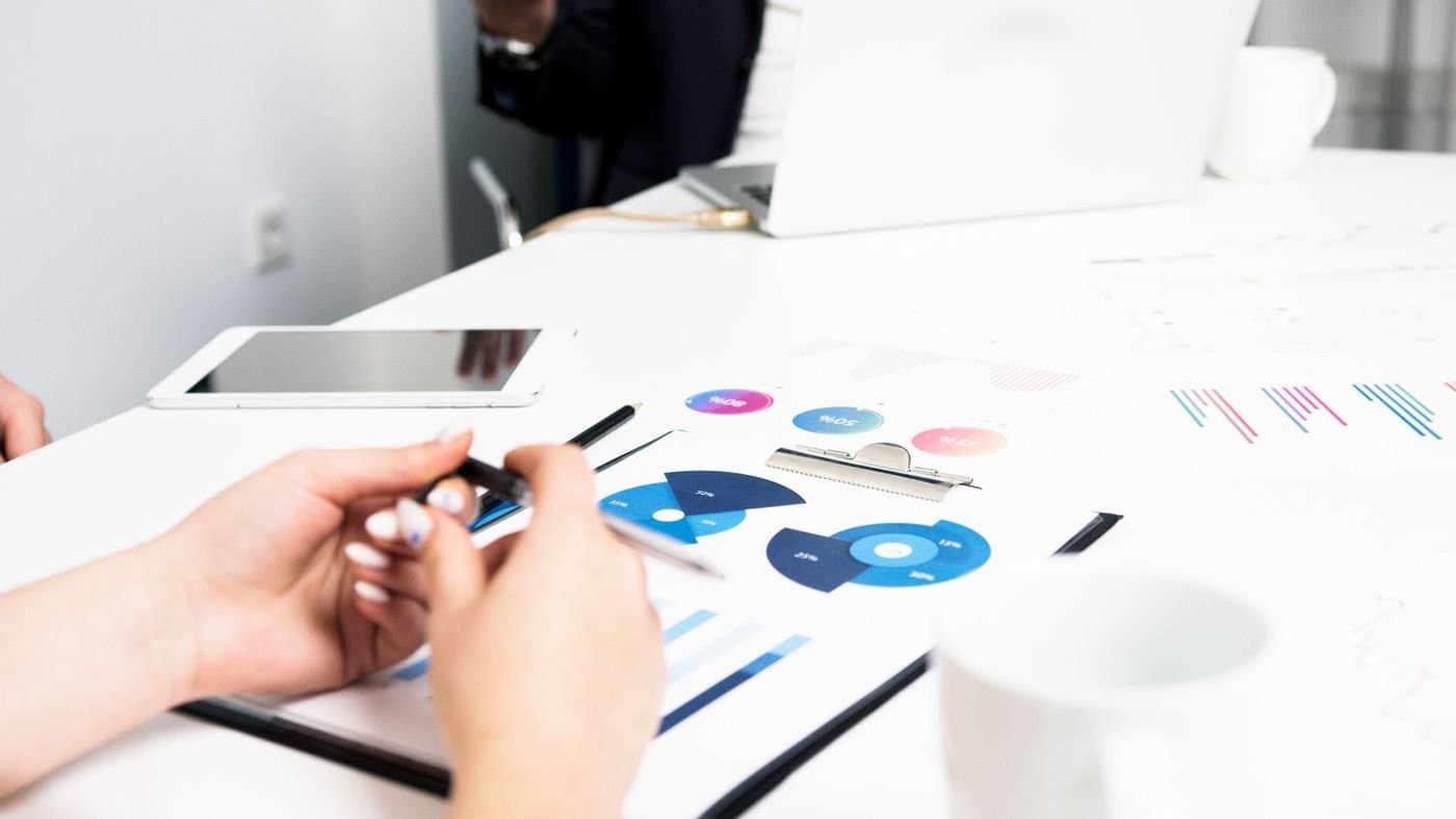 Couple reviewing financial charts and documents at a bright desk