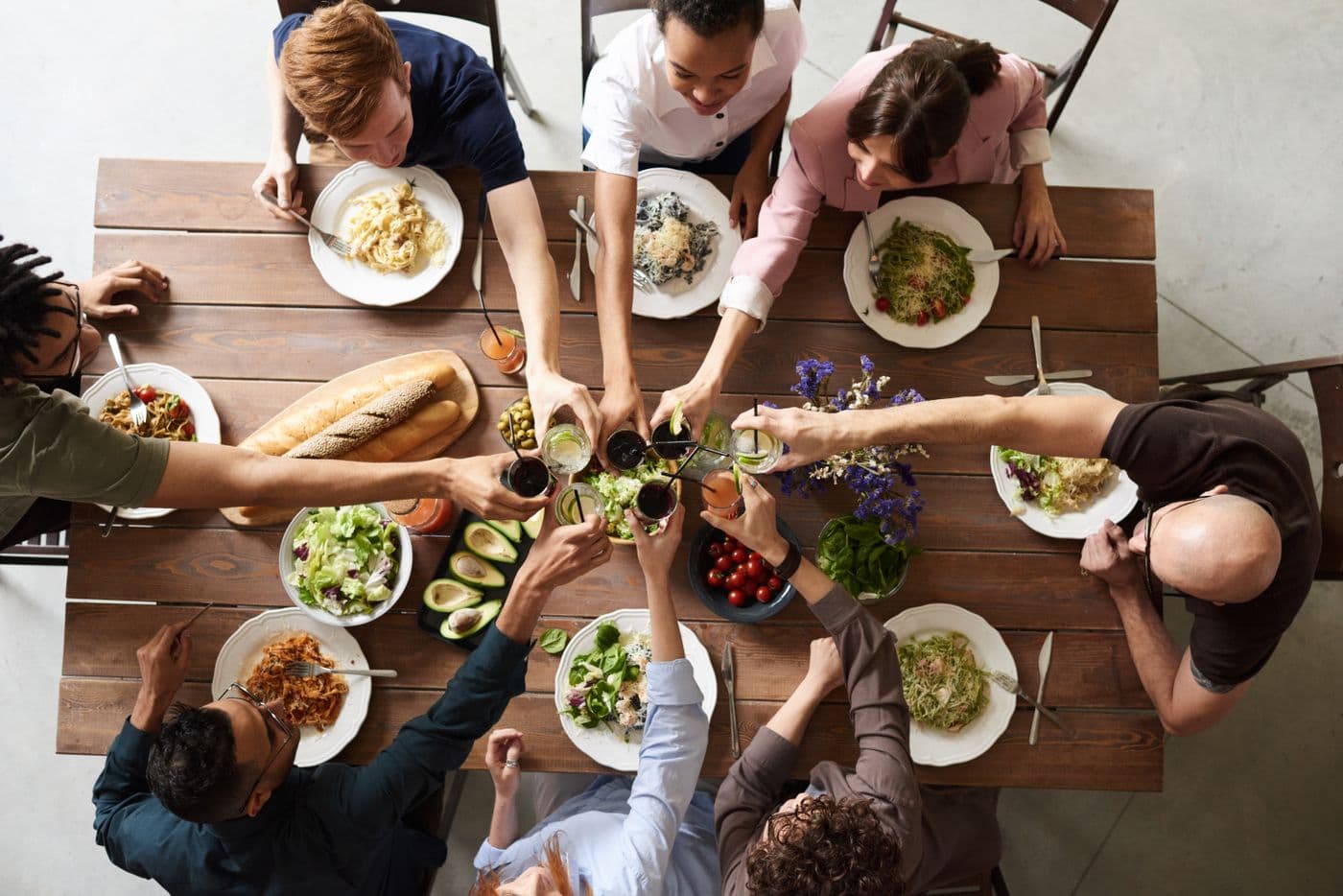 Multicultural friends toasting together over a shared meal, the social circle that includes you when family still does not