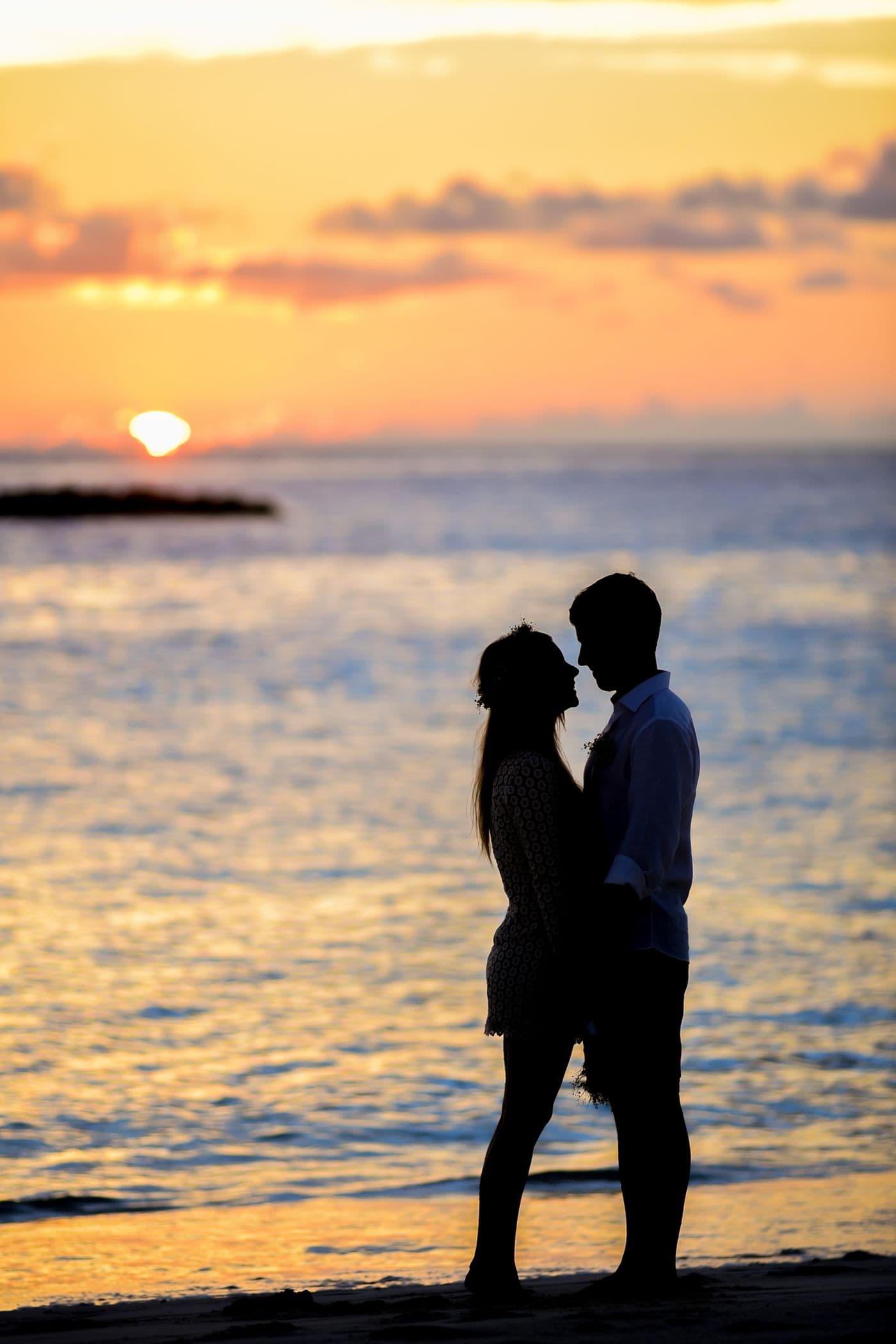 Couple sharing a quiet beach sunset moment before marriage