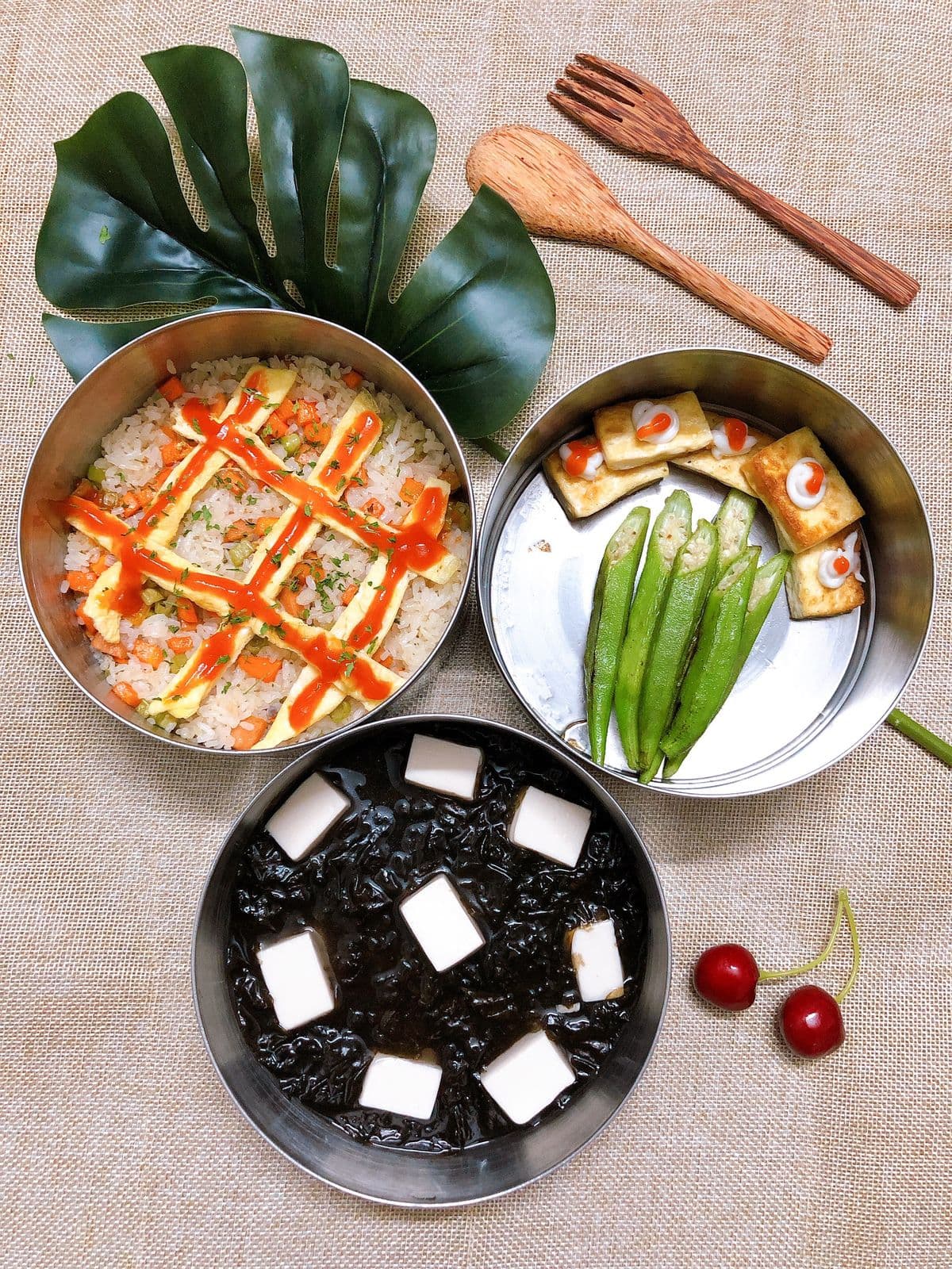 Homemade Asian lunch packed in stacked tiffin containers with rice and tofu