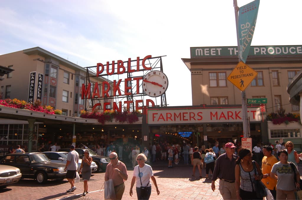 The Public Market Center sign and visitors at Pike Place Market in Seattle