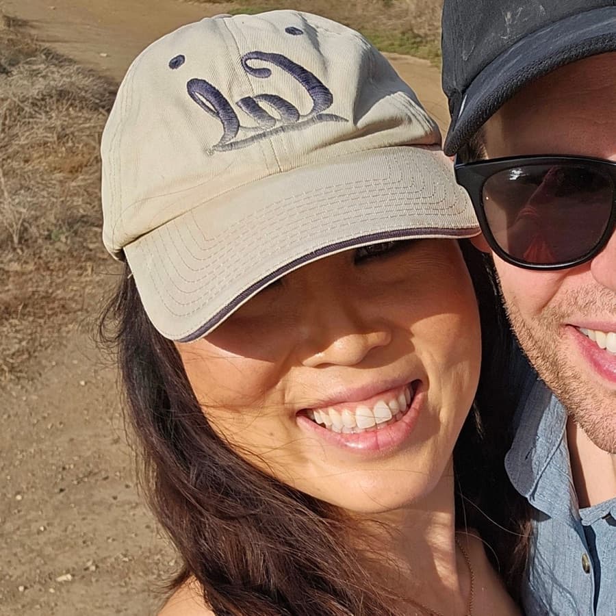 Juyun smiling outdoors in a Cal baseball cap