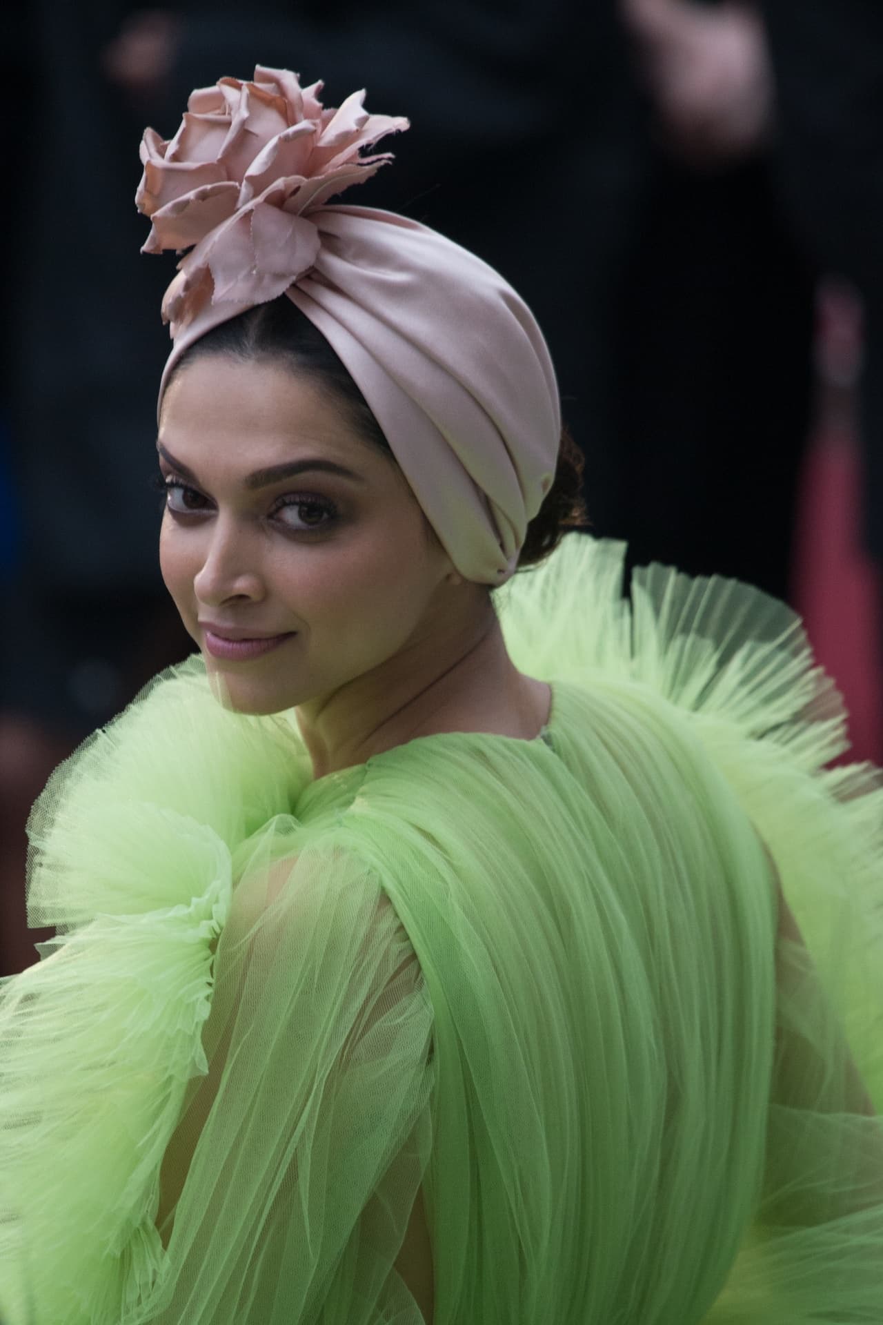 Deepika Padukone smiling over her shoulder in a lime-green tulle gown at the 2019 Cannes Film Festival