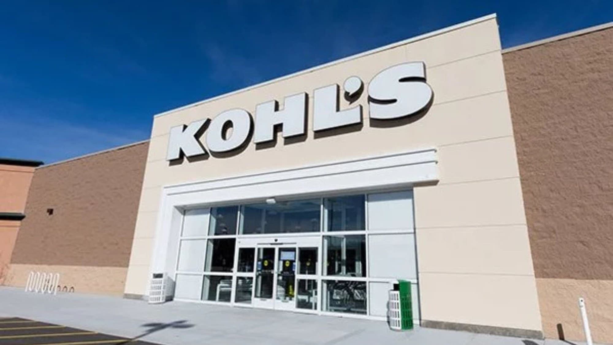 Kohl’s storefront entrance with the white KOHL’S logo centered on a beige facade under clear blue sky