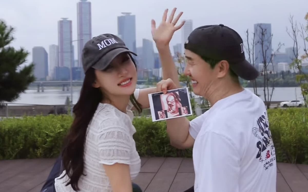 Lee Sang-ho and Kim Ja-yeon outdoors holding an ultrasound photo; she wears a cap reading MOM