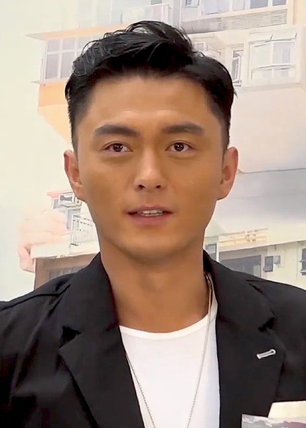 Hong Kong actor Mat Yeung in a black blazer and white tee looking toward camera at a promotional event