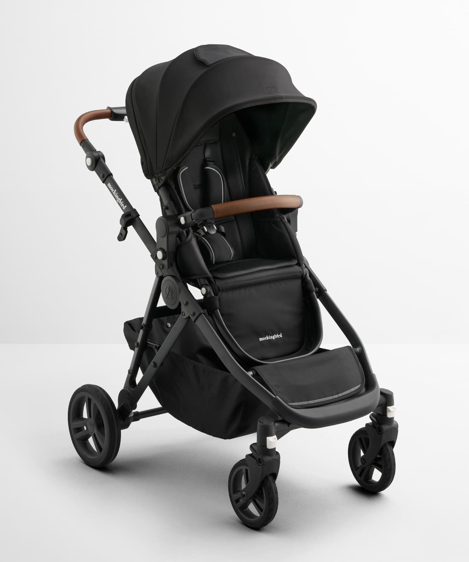 Mockingbird Single-to-Double stroller in black with brown handle accents, shown in studio product photography