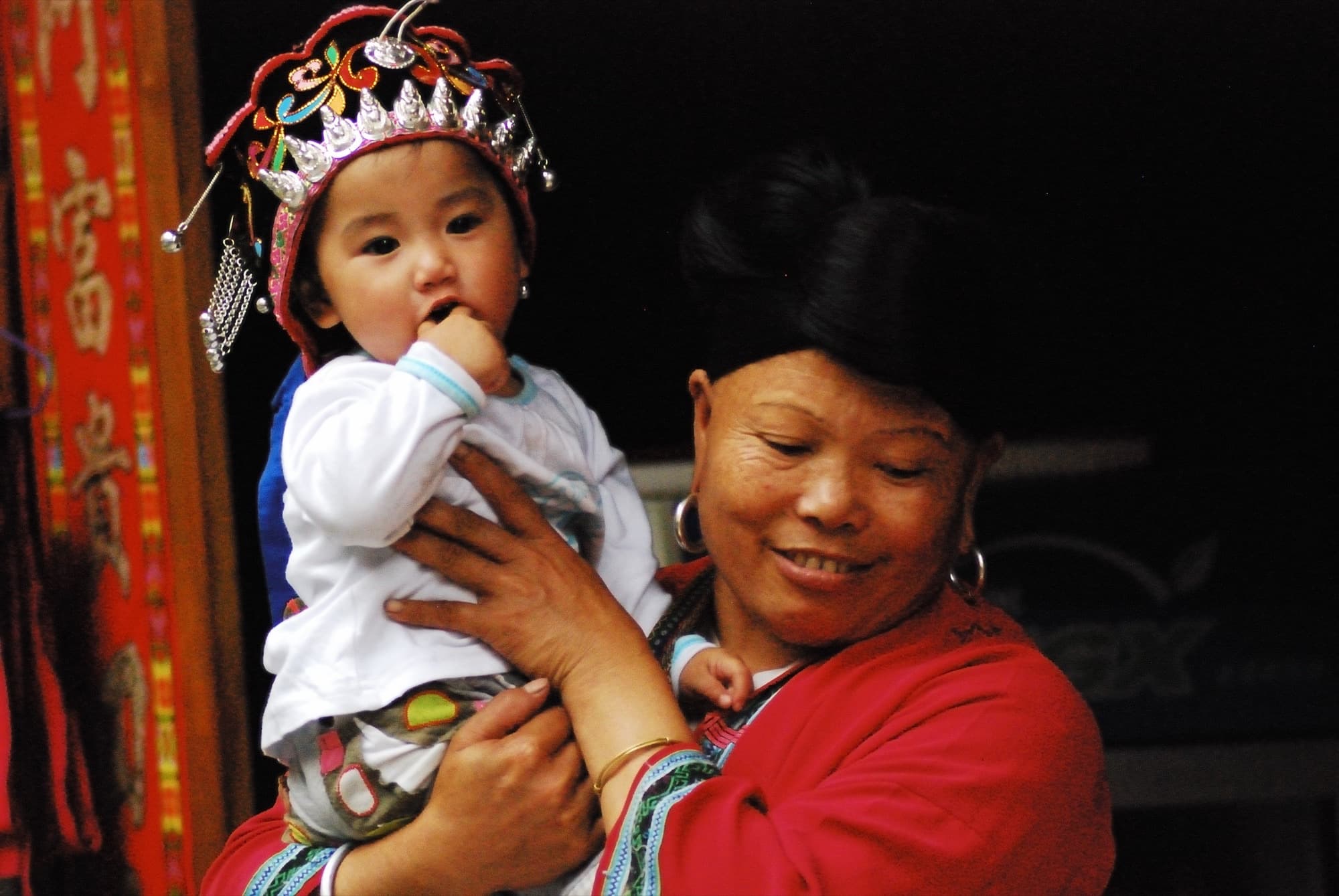 Red Yao grandmother and young child together in Longji Terrace Fields, Guangxi, China
