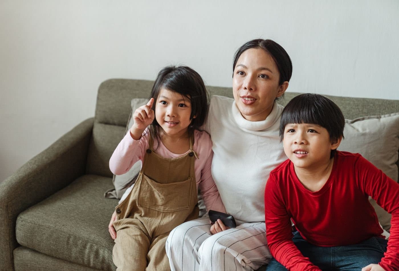 Family watching a movie together on the sofa at home