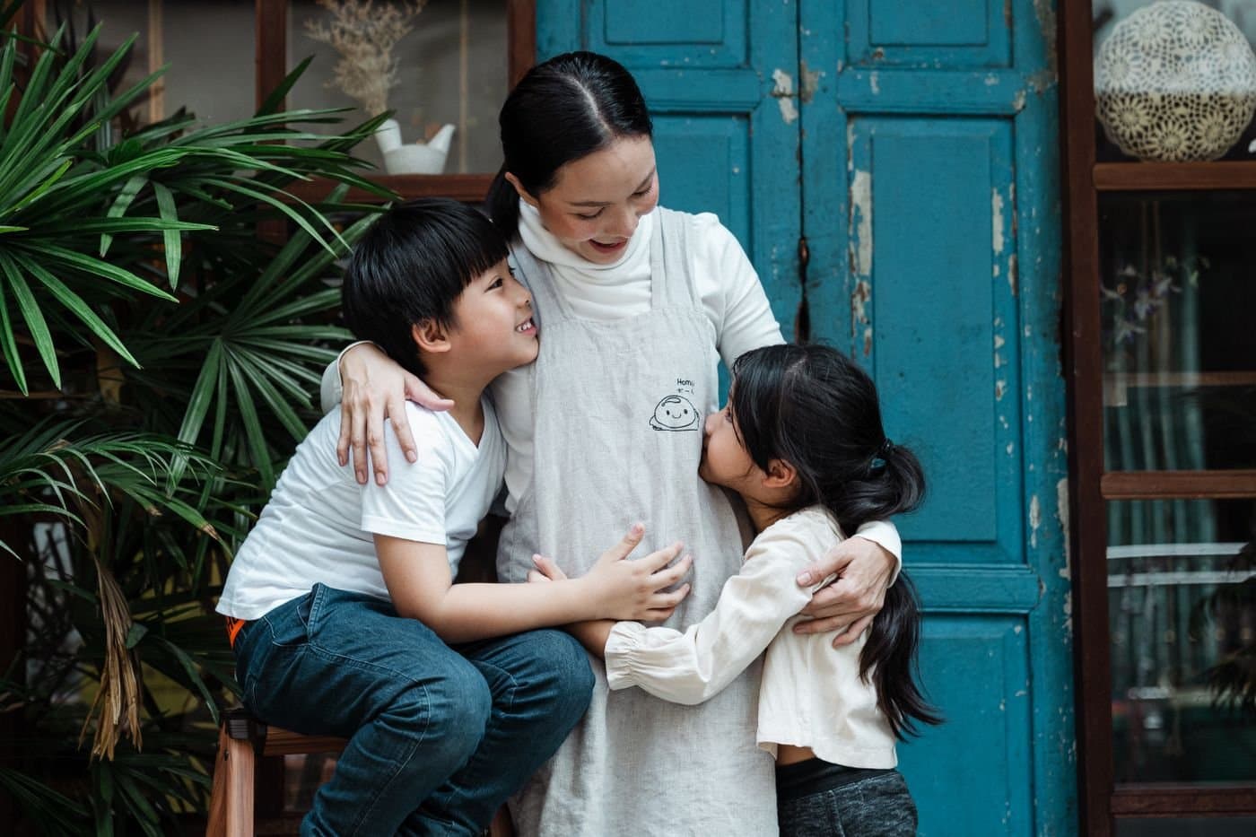 Parent hugging children outside their neighborhood home