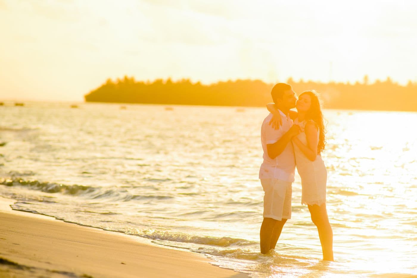 Couple embracing on the beach at sunset during a quiet romantic moment